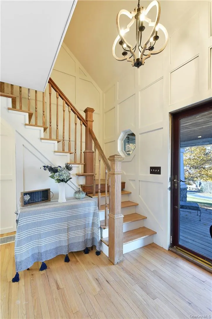Entrance foyer featuring high vaulted ceiling, an inviting chandelier, and light wood-type flooring Entrance foyer featuring high vaulted ceiling, an inviting chandelier, and light wood-type flooring
