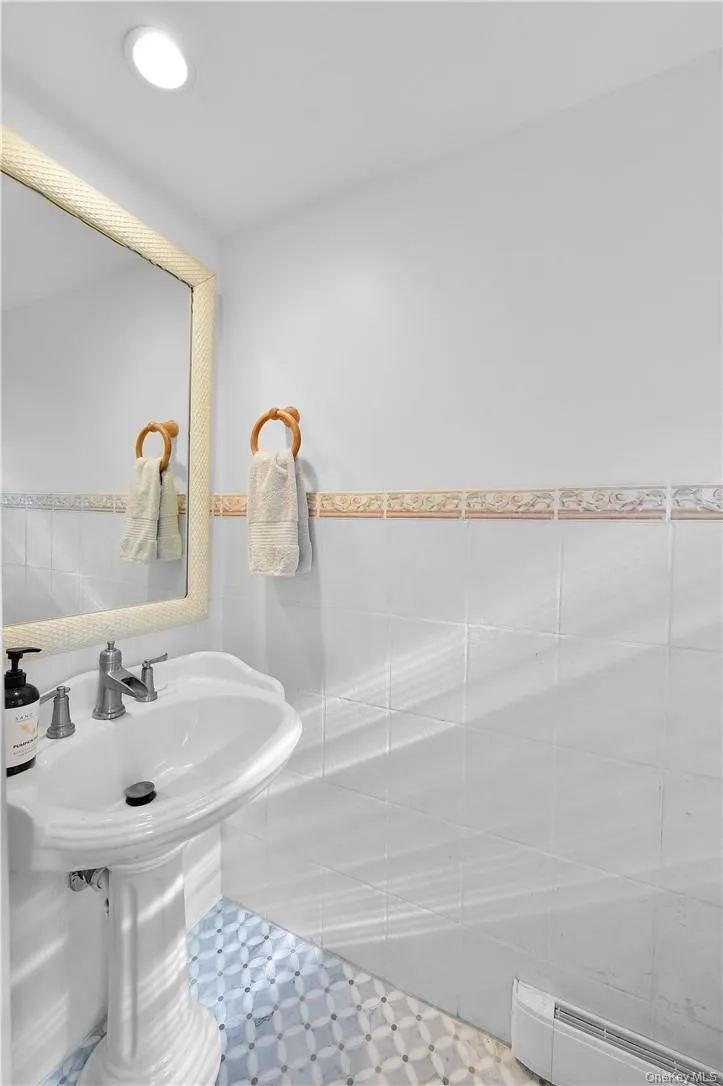Bathroom featuring tile walls and baseboard heating Bathroom featuring tile walls and baseboard heating