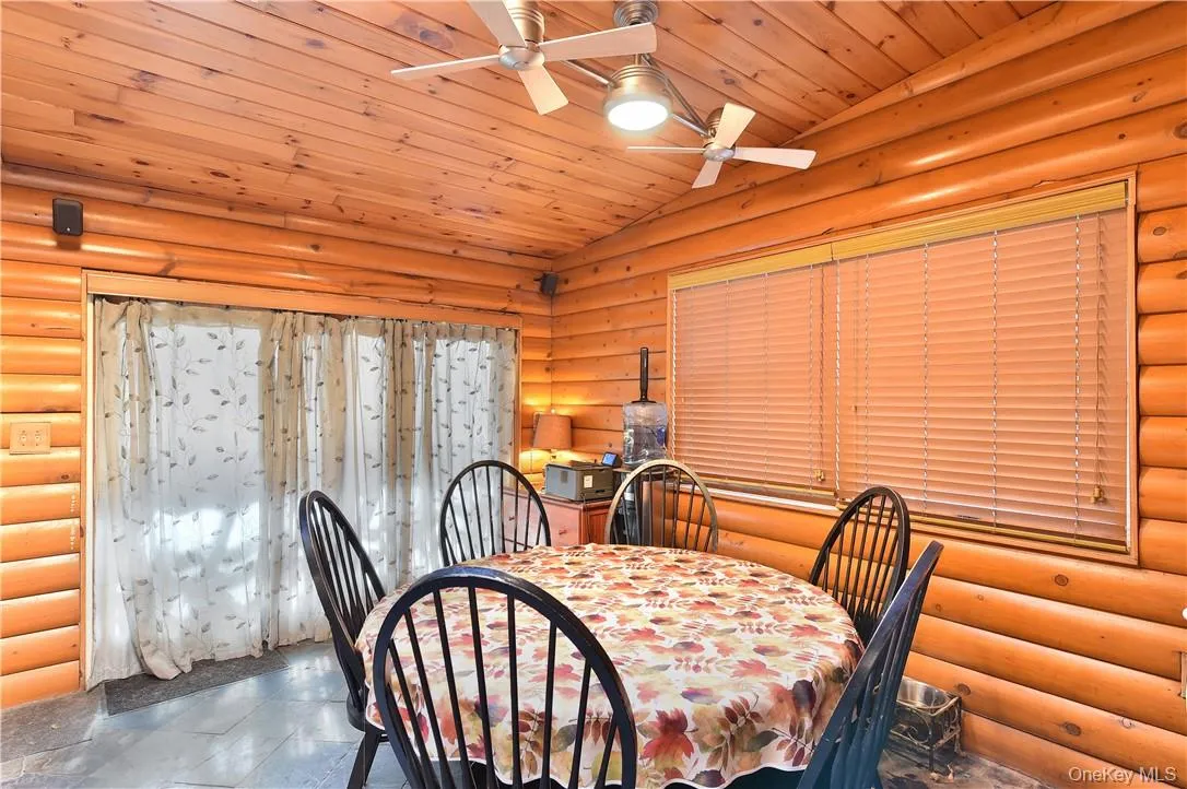 Dining room featuring ceiling fan, lofted ceiling, wood ceiling, and log walls Dining room featuring ceiling fan, lofted ceiling, wood ceiling, and log walls