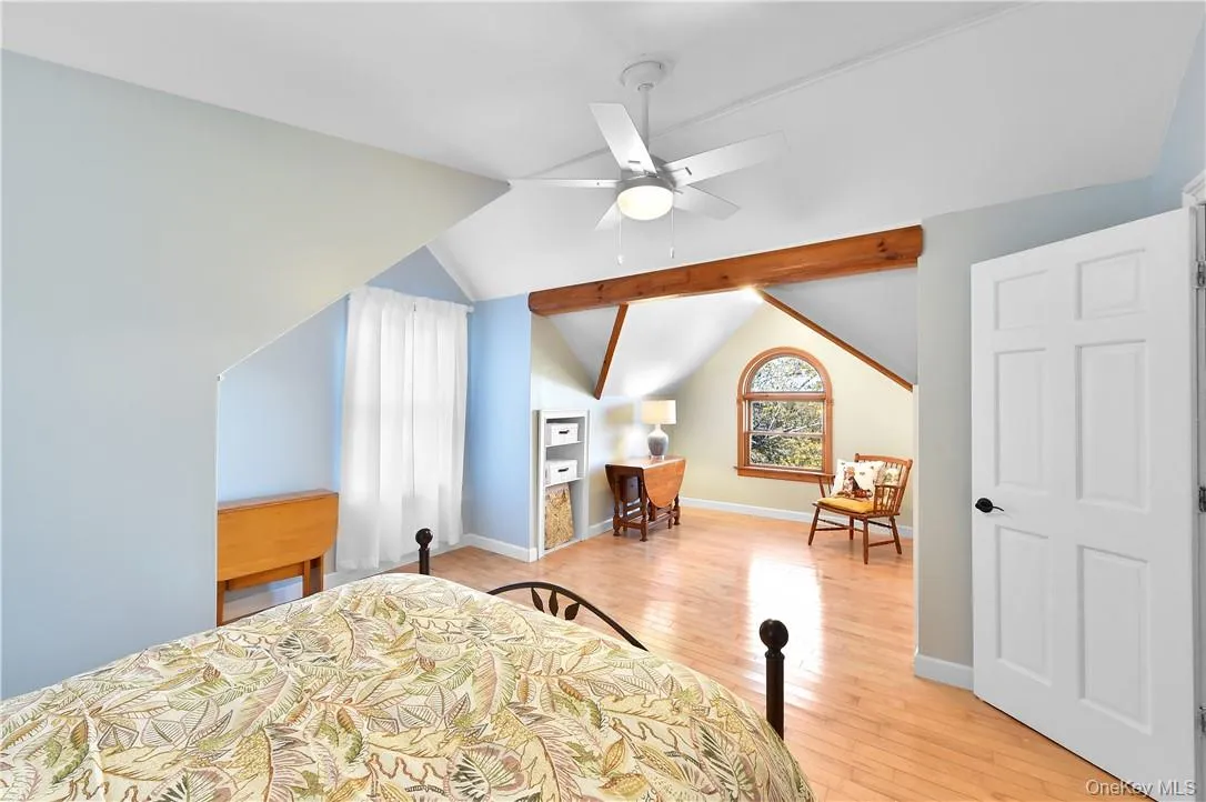 Bedroom with vaulted ceiling with beams, light hardwood / wood-style floors, and ceiling fan Bedroom with vaulted ceiling with beams, light hardwood / wood-style floors, and ceiling fan