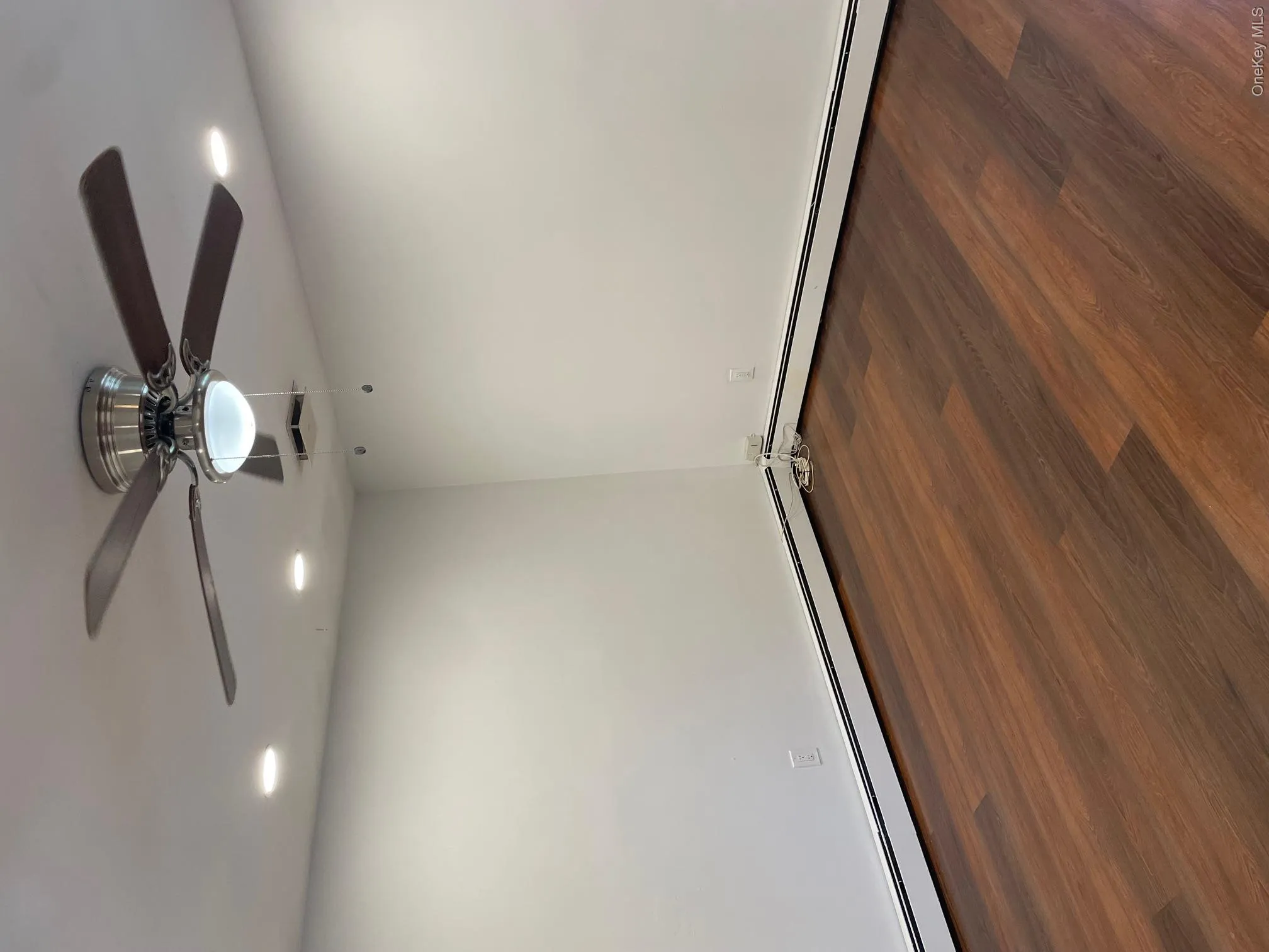 Wood-finish flooring with white walls and baseboard heating Wood-finish flooring with white walls and baseboard heating