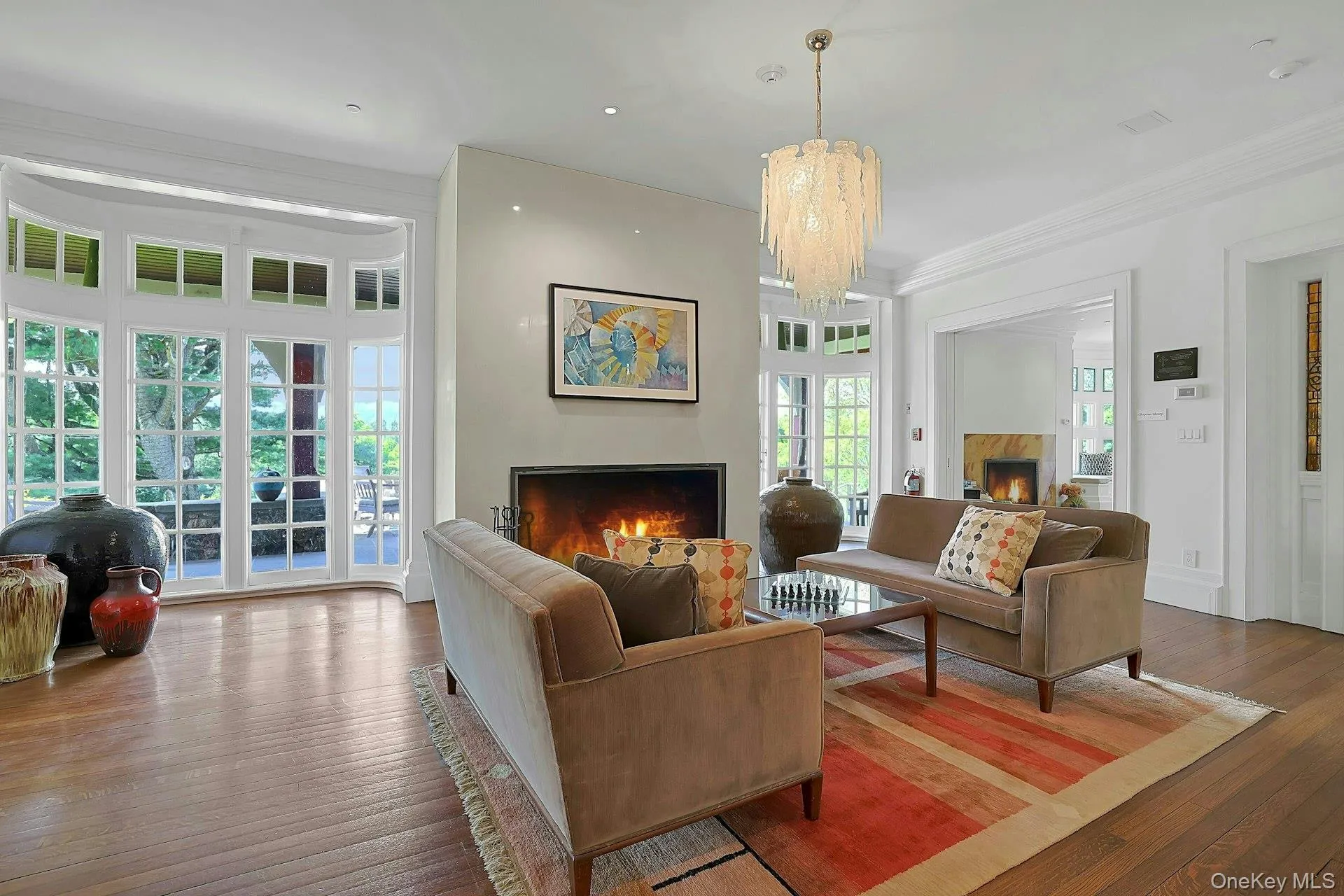 With a stunning, contemporary glass chandelier and walls of original windows and French doors, the expansive living room is a warm heart to the home. With a stunning, contemporary glass chandelier and walls of original windows and French doors, the expansive living room is a warm heart to the home.