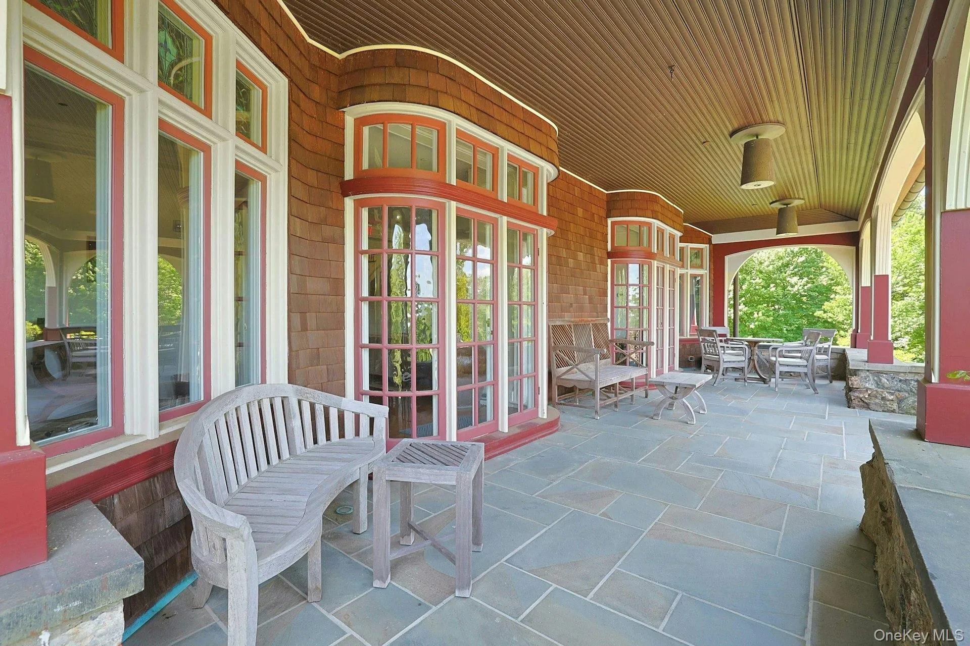 The deep and wide slate front porch is an entertainer's dream. After dinner, the party can move out to this covered space. Pick any of the many seating areas that overlook the grounds and watch as the sun sets over the highlands in the distance. The deep and wide slate front porch is an entertainer's dream. After dinner, the party can move out to this covered space. Pick any of the many seating areas that overlook the grounds and watch as the sun sets over the highlands in the distance.