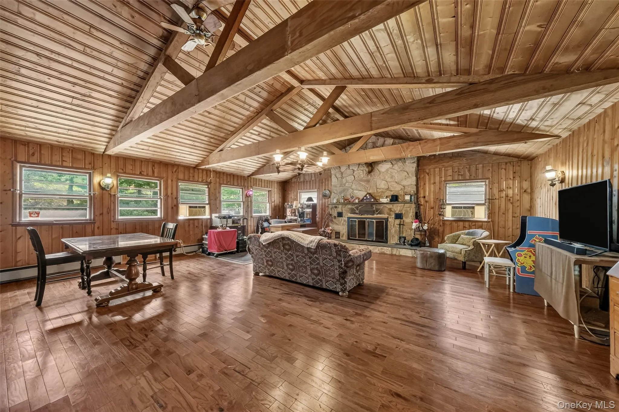 Enormous Living Room with floor to ceiling stone fireplace, hardwood floors and beams Enormous Living Room with floor to ceiling stone fireplace, hardwood floors and beams