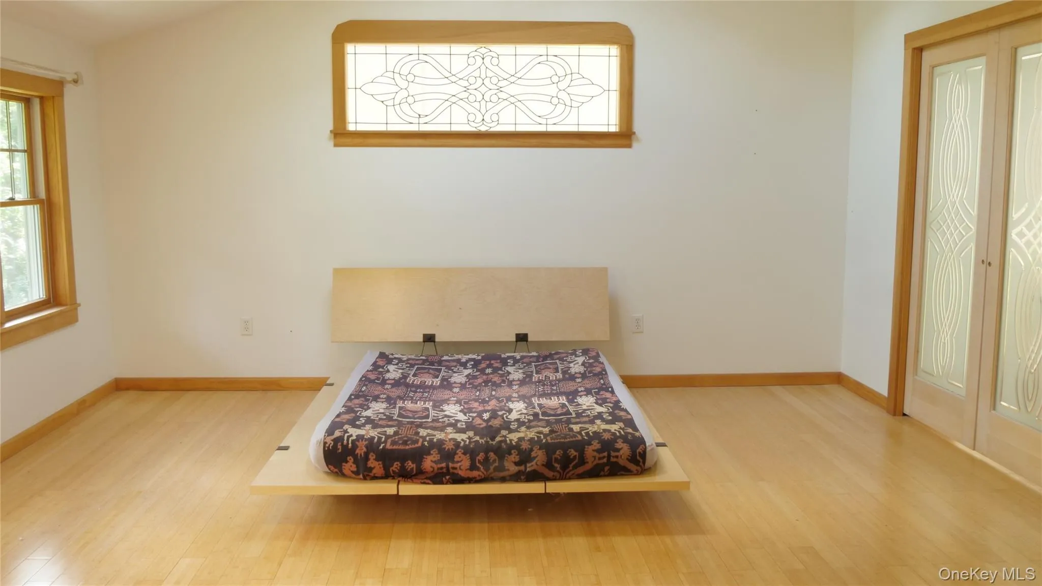 Hardwood flooring, stained glass window and walk-in closet completes this elegant primary suite Hardwood flooring, stained glass window and walk-in closet completes this elegant primary suite