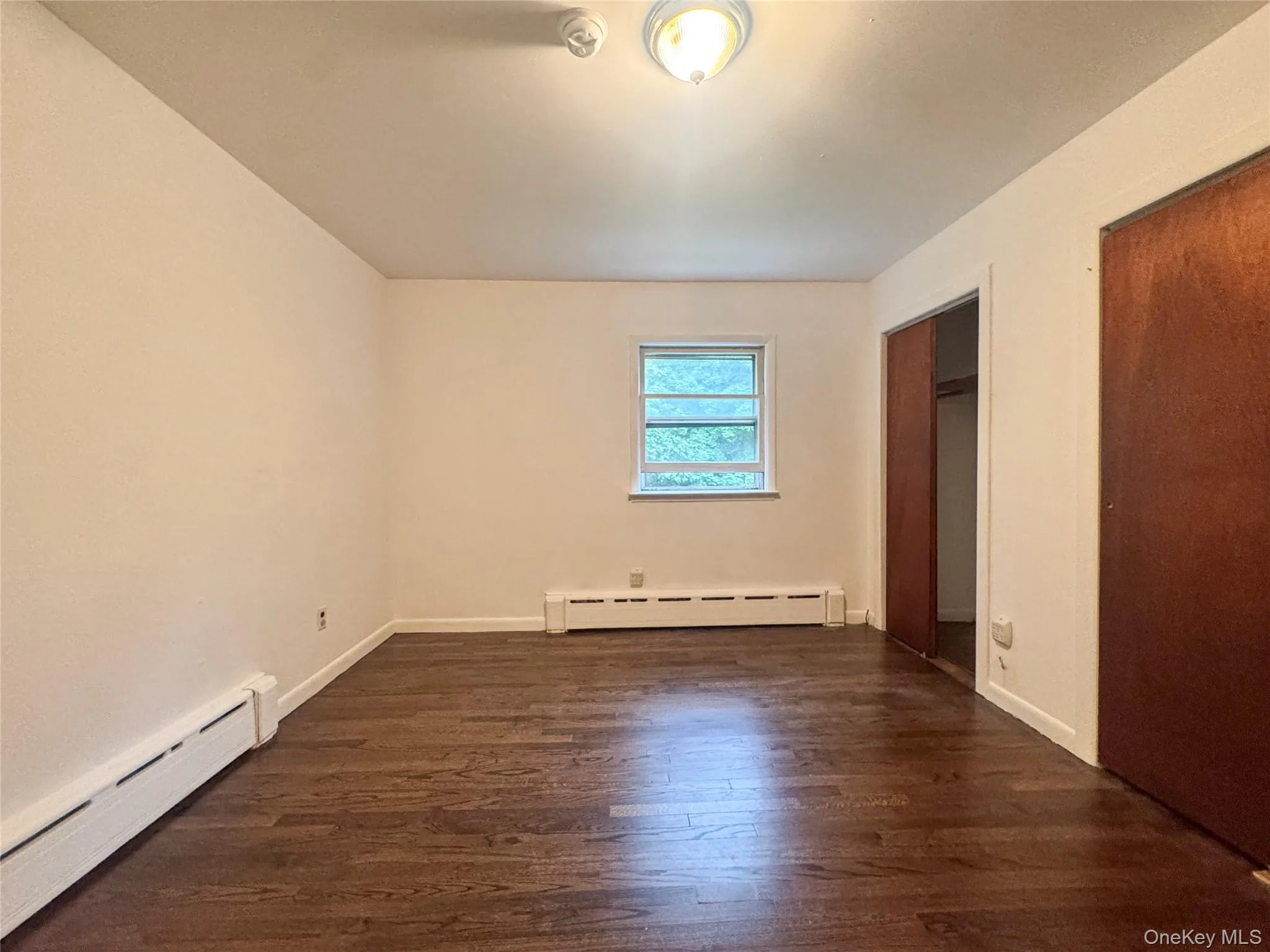 Bedroom with two closets. Cast iron base board heat. Bedroom with two closets. Cast iron base board heat.