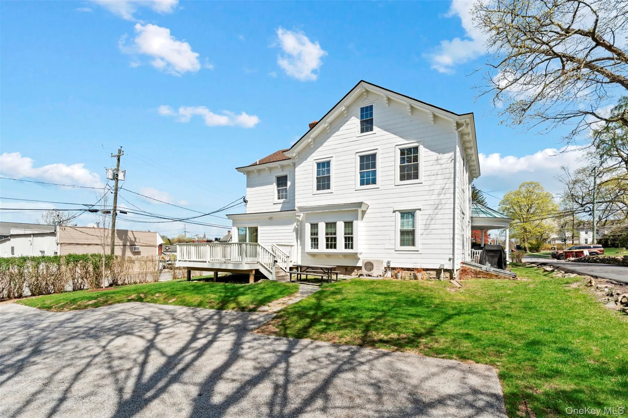 Back of house featuring a lawn, a wooden deck, and off street parking Back of house featuring a lawn, a wooden deck, and off street parking