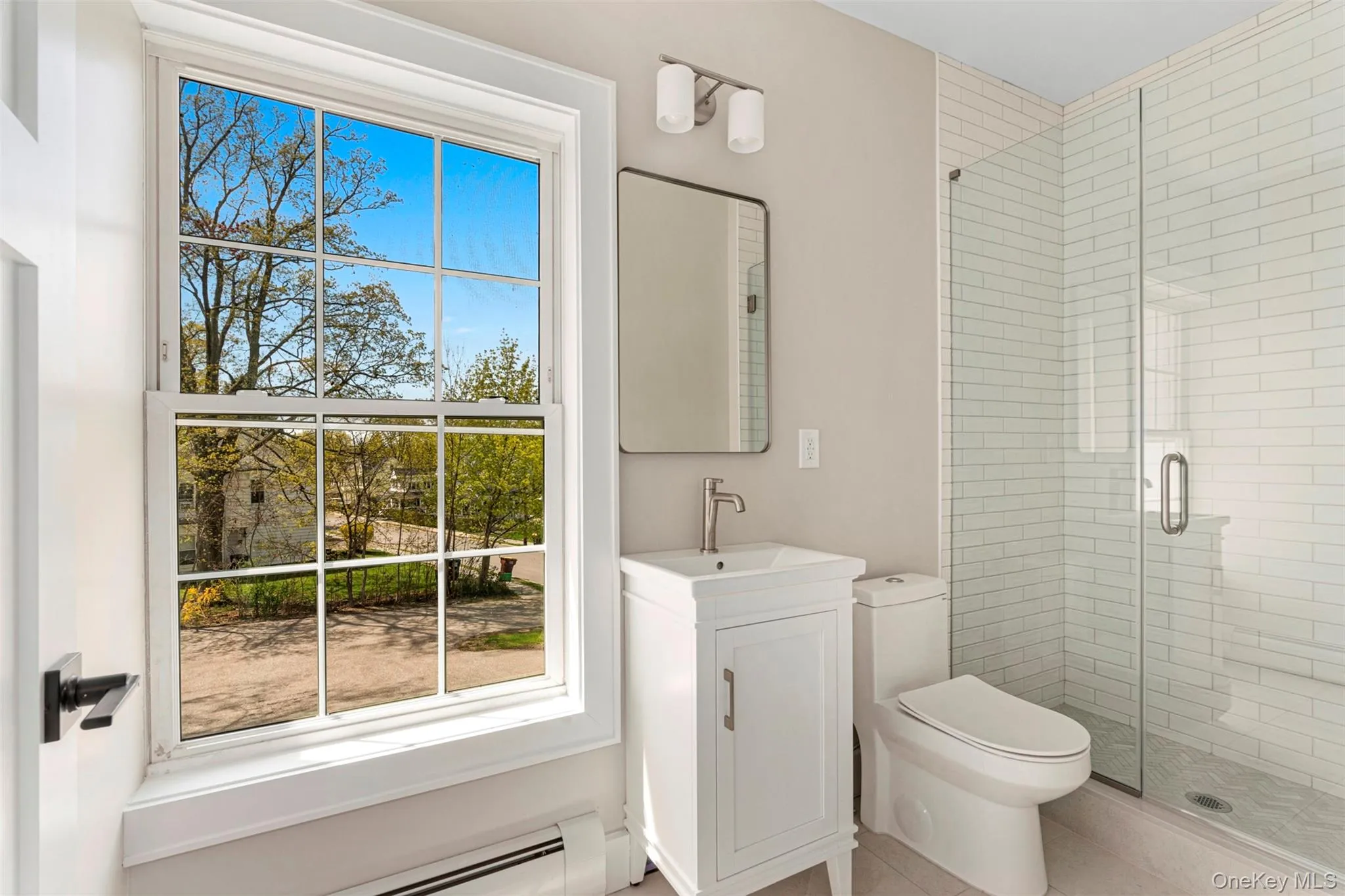 Bathroom featuring plenty of natural light, toilet, tile patterned flooring, and a stall shower Bathroom featuring plenty of natural light, toilet, tile patterned flooring, and a stall shower