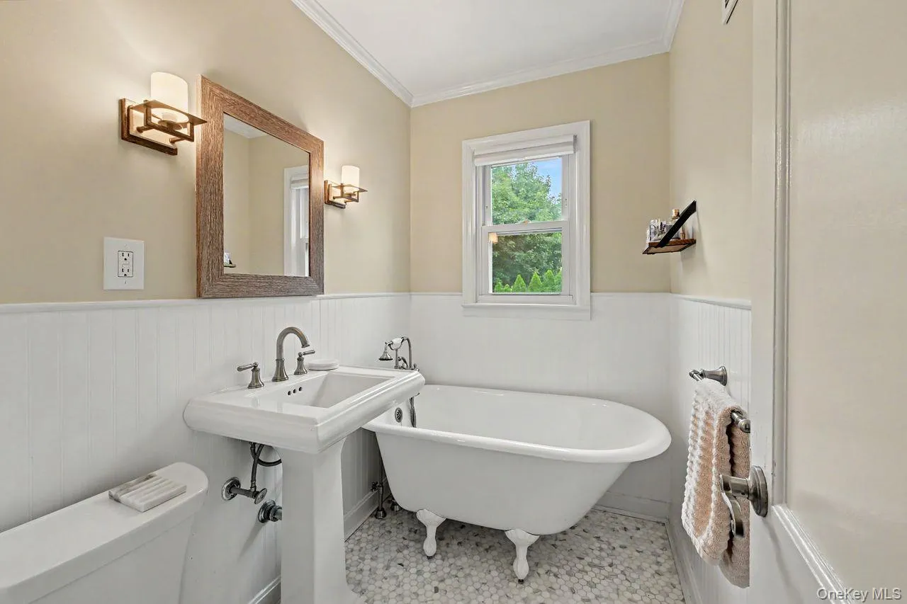 Bathroom on the second floor boasts a soaking tub, tile floor and wainscoting. Bathroom on the second floor boasts a soaking tub, tile floor and wainscoting.