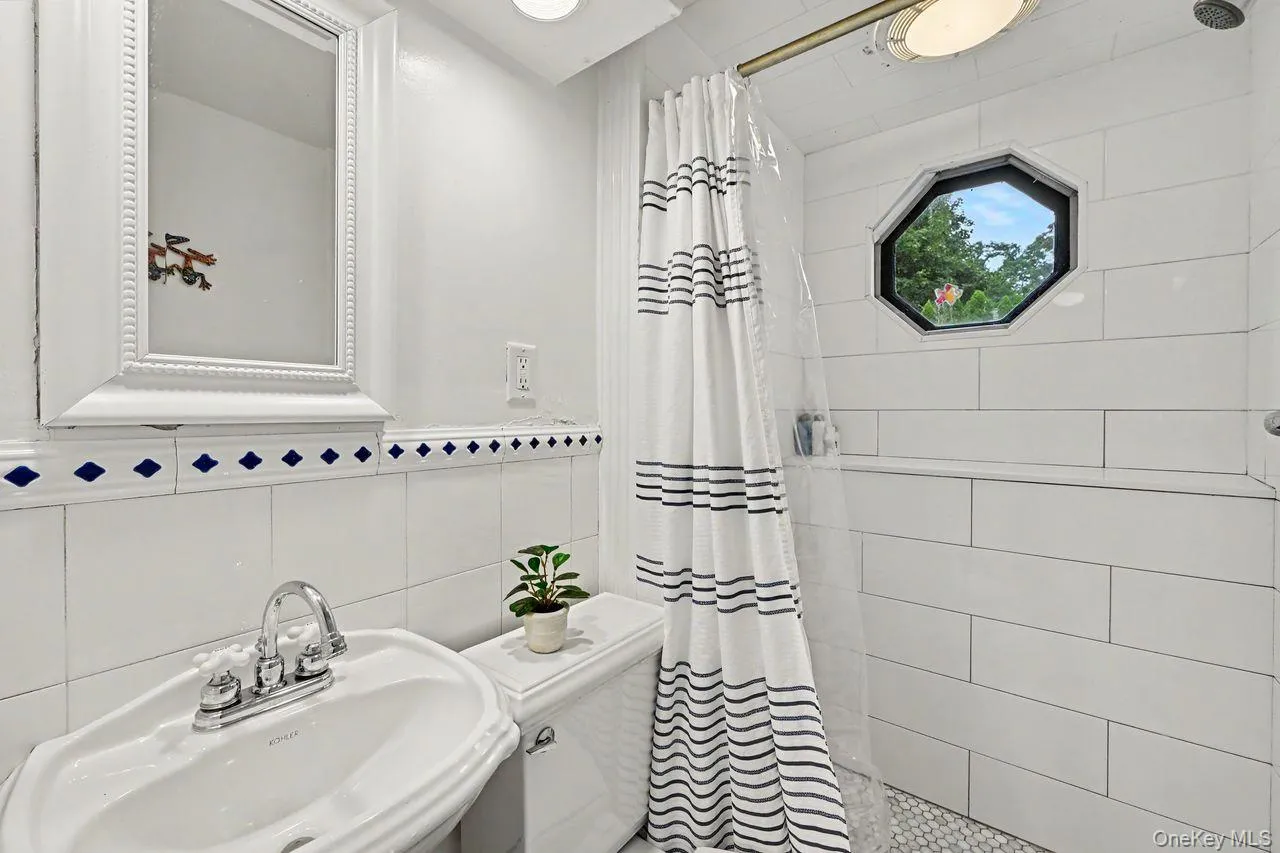 Lower level bath has tiled shower and octagon window. Lower level bath has tiled shower and octagon window.
