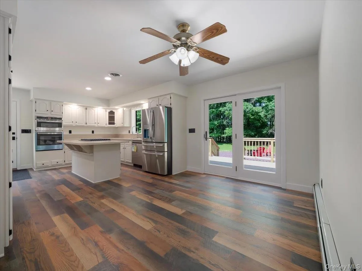 Long view of kitchen from corner of dining room area - doors to deck Long view of kitchen from corner of dining room area - doors to deck