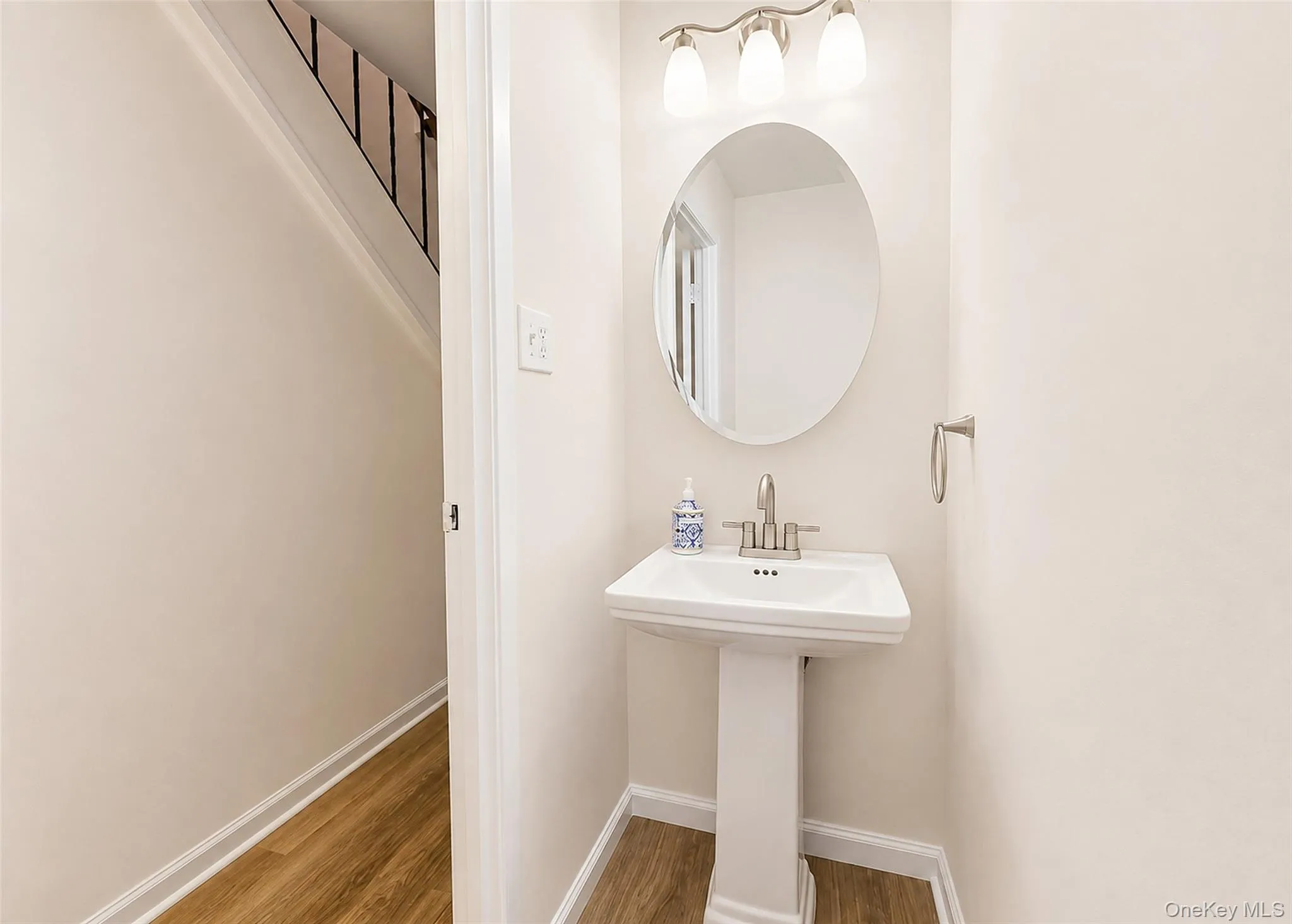 Half Bath With New Wide-Plank Oak Laminate Flooring & Updated Pedestal Sink. Half Bath With New Wide-Plank Oak Laminate Flooring & Updated Pedestal Sink.