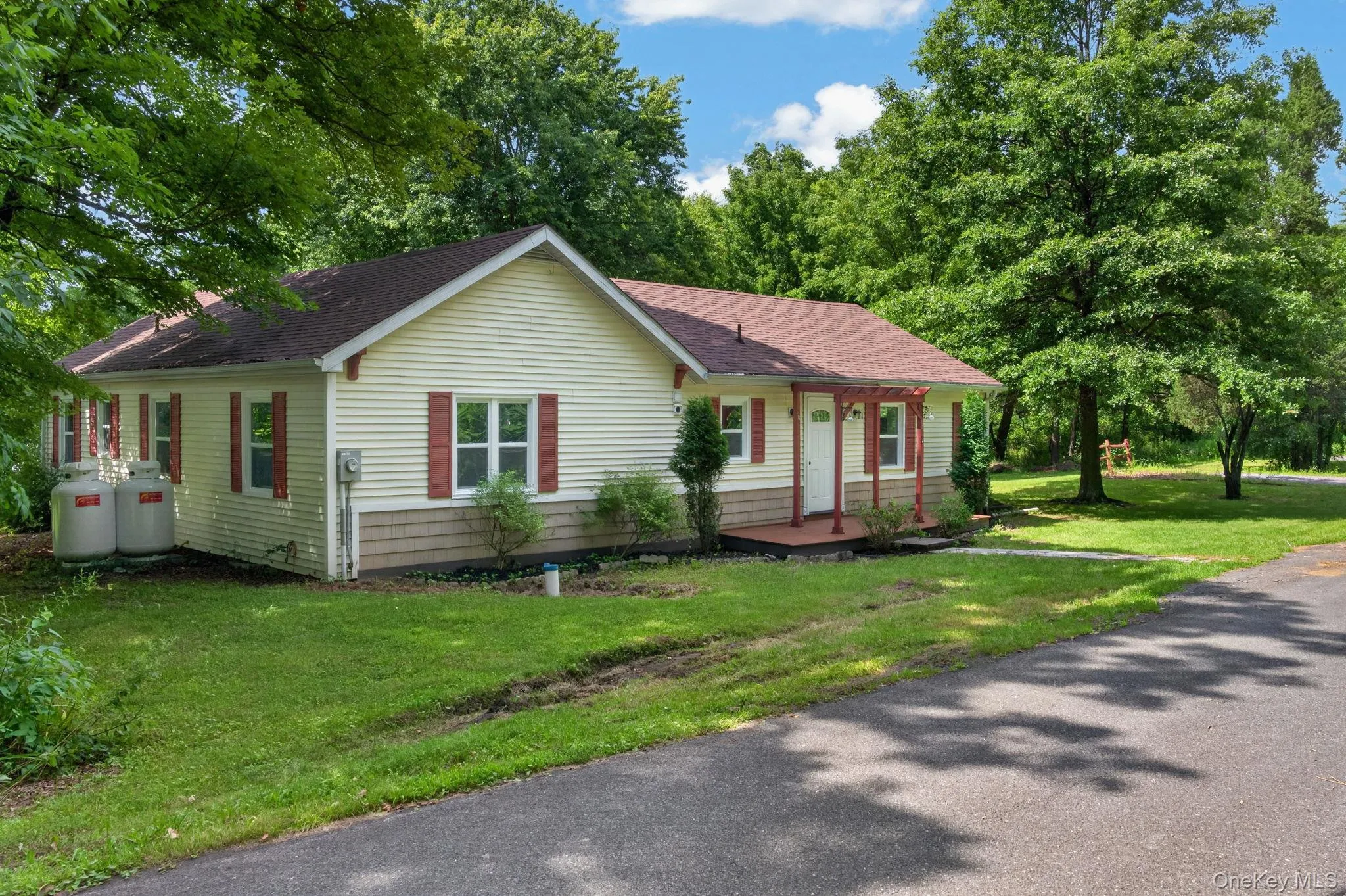 Siding exterior with red shutters, a welcoming front porch, and a pitched roof Siding exterior with red shutters, a welcoming front porch, and a pitched roof