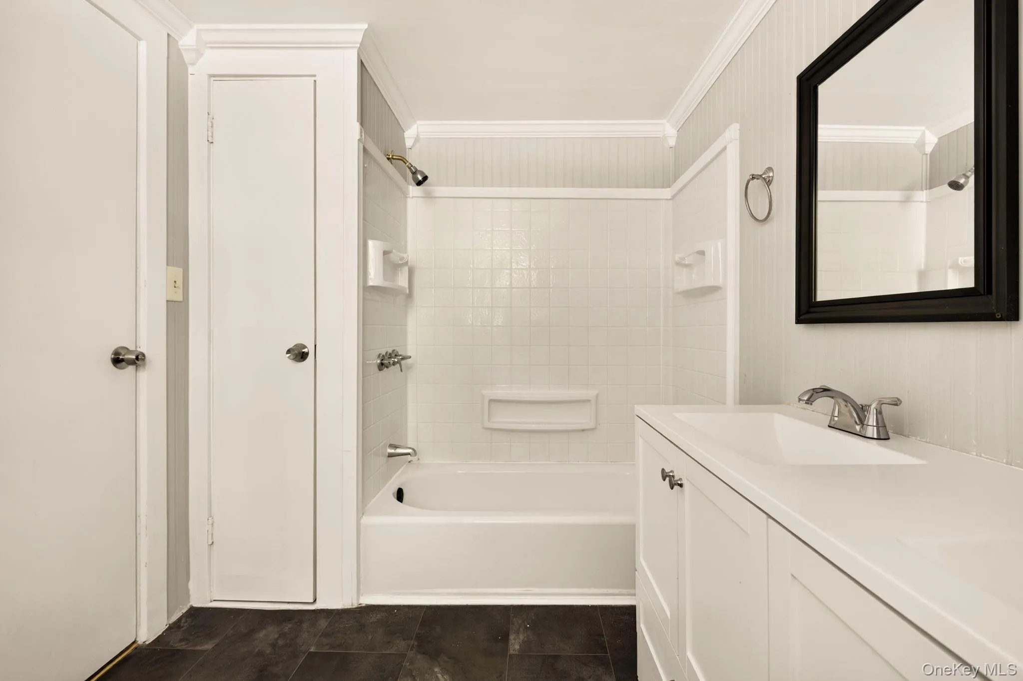 White vanity with integrated sink, chrome faucet, and framed mirror White vanity with integrated sink, chrome faucet, and framed mirror