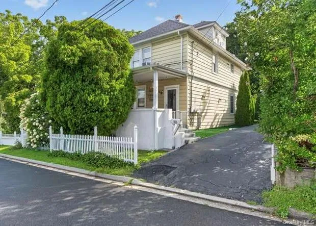 Two-story residence with covered porch and white picket fence Two-story residence with covered porch and white picket fence