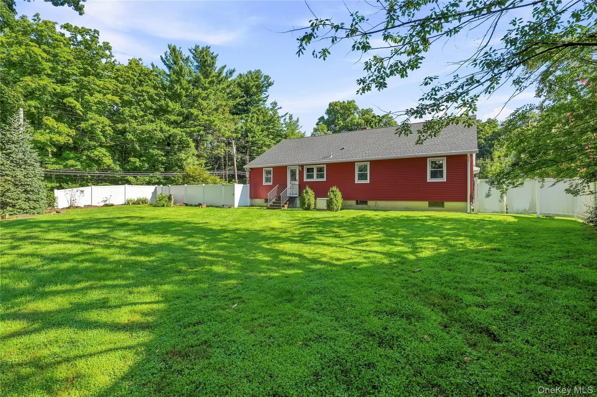 Expansive green lawn, mature perimeter trees, and a durable vinyl fence enclosing the property Expansive green lawn, mature perimeter trees, and a durable vinyl fence enclosing the property