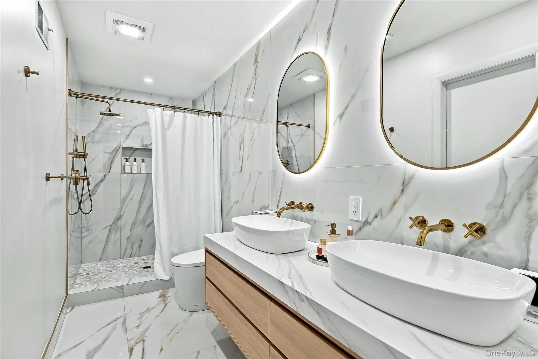 Renovated primary bathroom with double sinks and large walk-in shower Renovated primary bathroom with double sinks and large walk-in shower