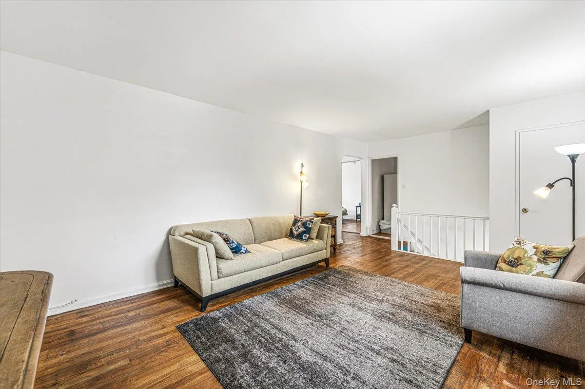 Hardwood flooring throughout, white walls, and a white interior door Hardwood flooring throughout, white walls, and a white interior door