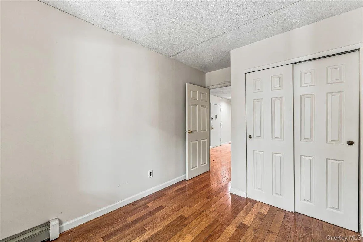 Hardwood flooring, painted walls, white trim, and a white paneled door Hardwood flooring, painted walls, white trim, and a white paneled door