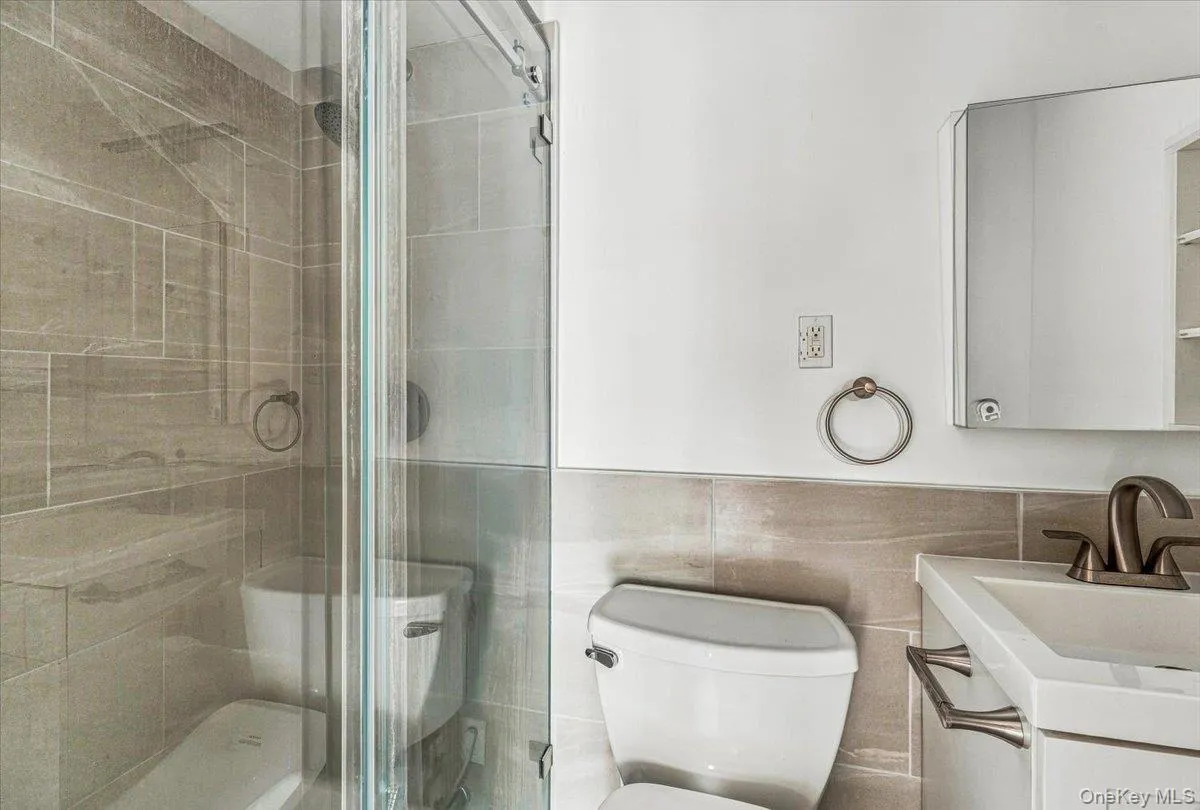Glass-enclosed shower with tiled walls and a built-in bench Glass-enclosed shower with tiled walls and a built-in bench