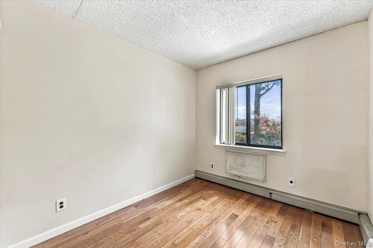 Wood-finish flooring with a window offering natural light Wood-finish flooring with a window offering natural light