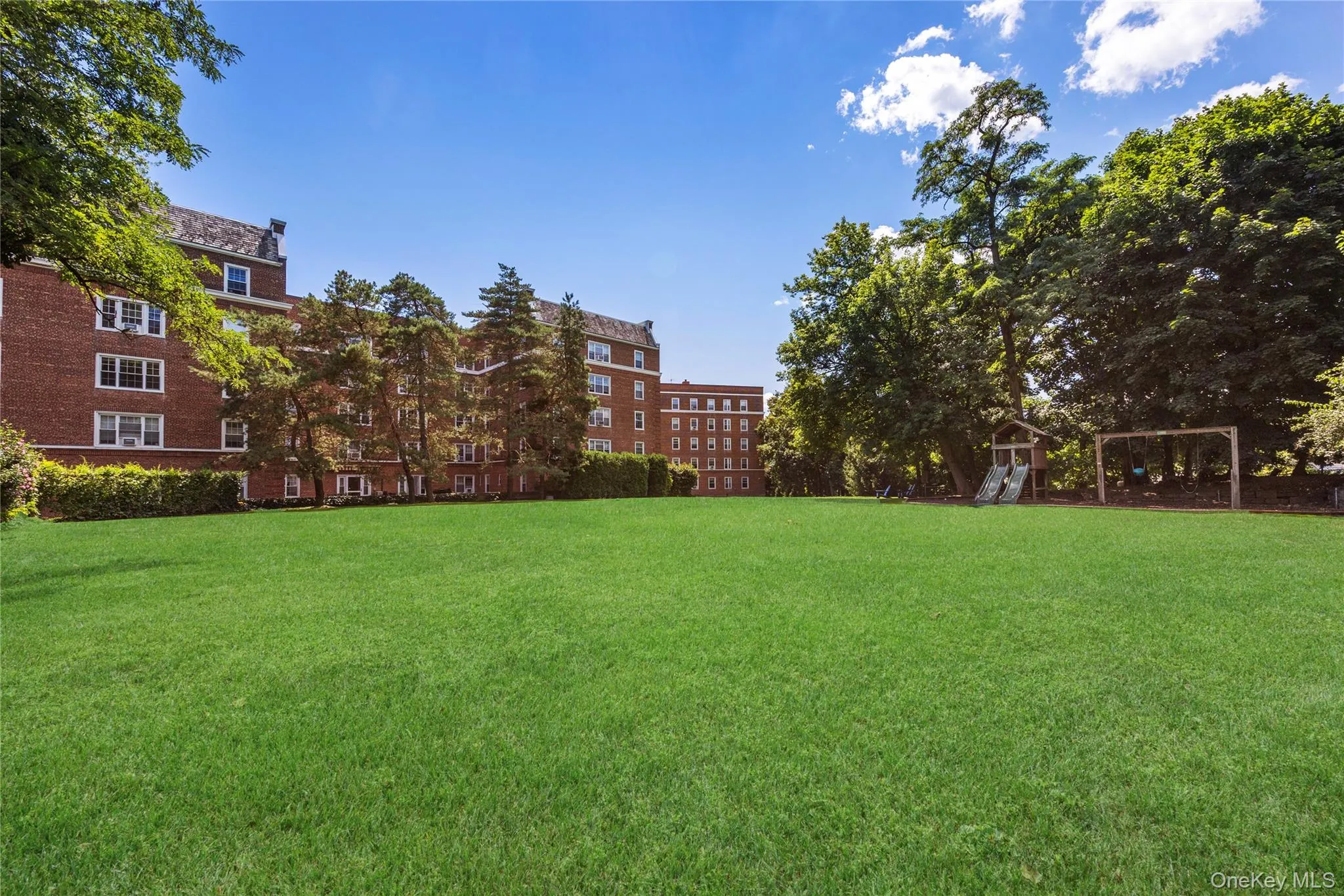 Expansive lawn area with mature trees for community enjoyment Expansive lawn area with mature trees for community enjoyment