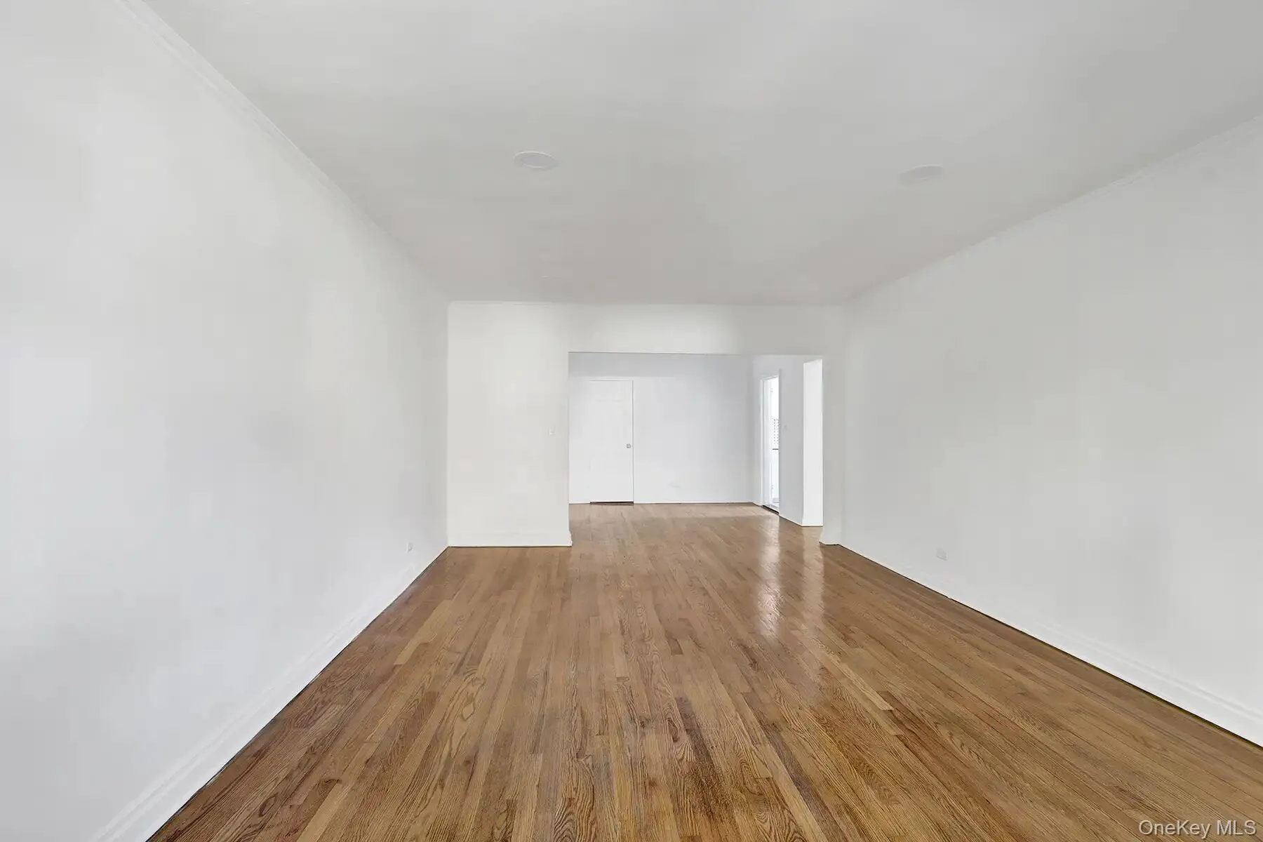 Hardwood flooring, crisp white walls, recessed lighting, and an open entryway Hardwood flooring, crisp white walls, recessed lighting, and an open entryway