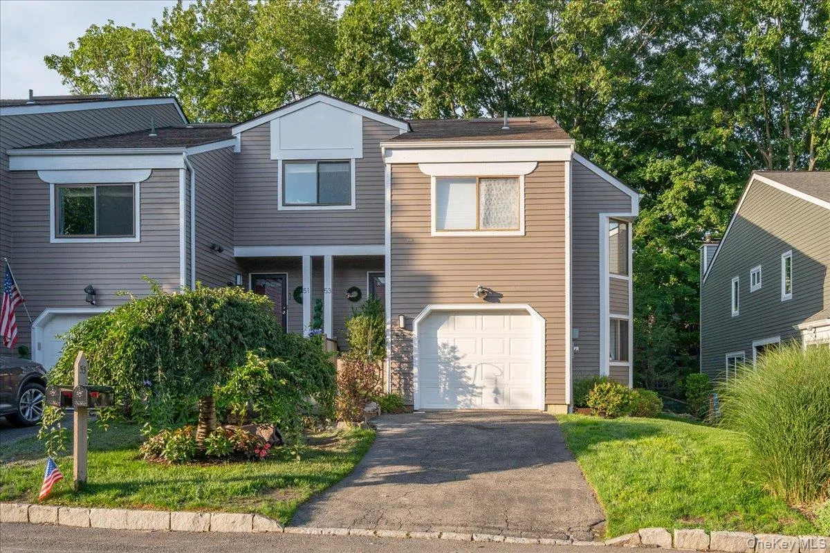 Two-story exterior with horizontal siding, an attached garage, a driveway, and mature landscaping Two-story exterior with horizontal siding, an attached garage, a driveway, and mature landscaping