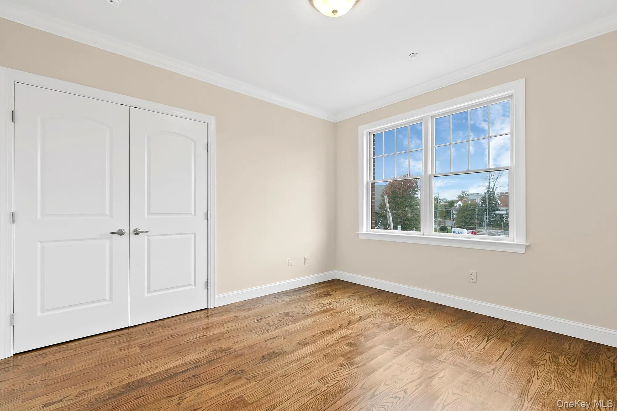 2nd bedroom with ornamental molding, a closet, and light hardwood / wood-style floors 2nd bedroom with ornamental molding, a closet, and light hardwood / wood-style floors