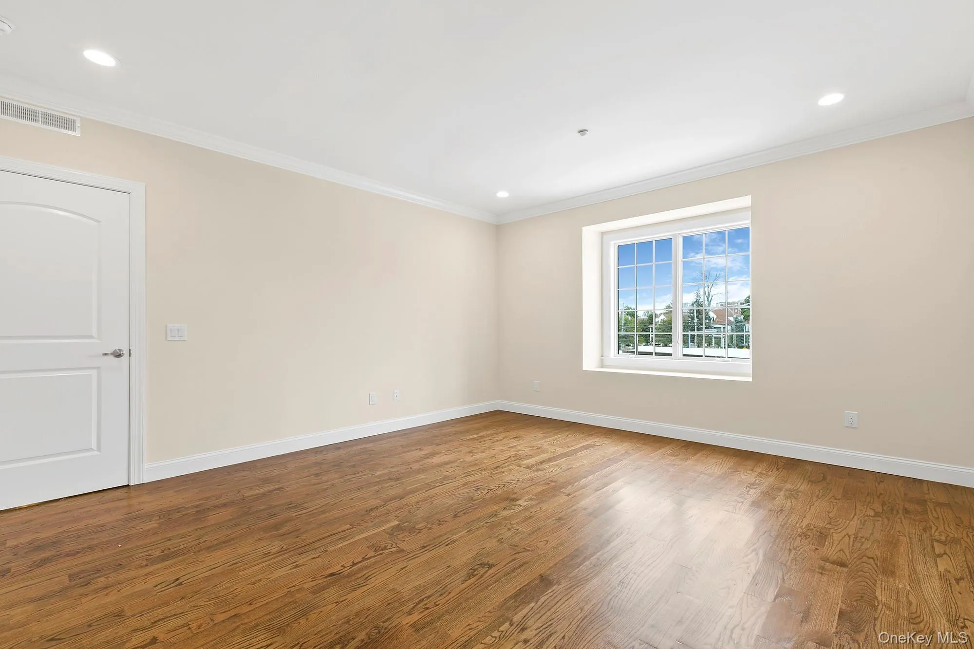 Spare room featuring hardwood / wood-style flooring and ornamental molding Spare room featuring hardwood / wood-style flooring and ornamental molding