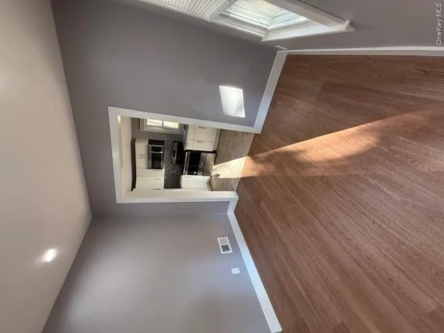 Unfurnished living room with dark wood-style floors and recessed lighting Unfurnished living room with dark wood-style floors and recessed lighting