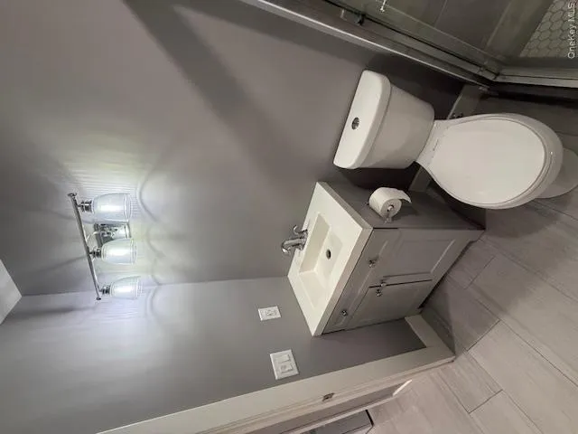 Bathroom with vanity, a shower stall, and wood finish floors Bathroom with vanity, a shower stall, and wood finish floors