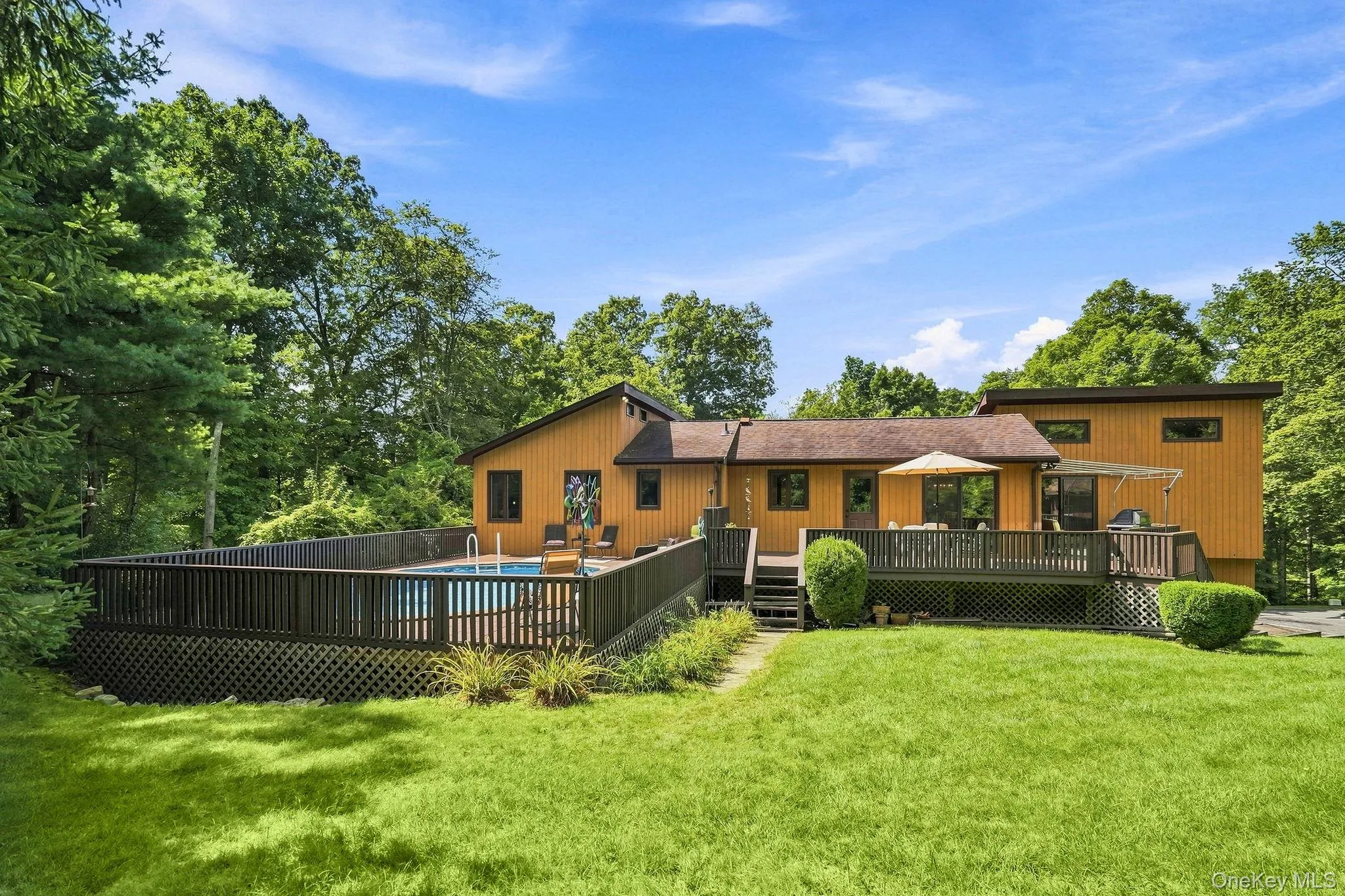 Expansive backyard with a swimming pool, surrounding privacy fence, and large multi-level deck Expansive backyard with a swimming pool, surrounding privacy fence, and large multi-level deck