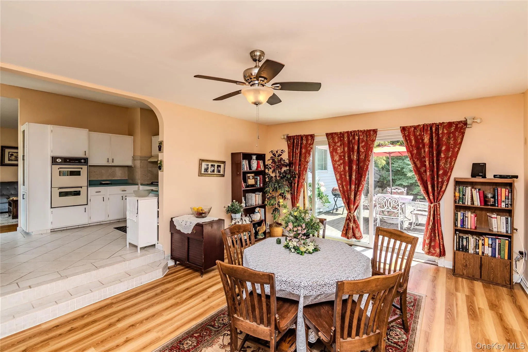 Wood-finish flooring, ceiling fan with integrated lighting, built-in double wall oven, and sliding glass doors Wood-finish flooring, ceiling fan with integrated lighting, built-in double wall oven, and sliding glass doors