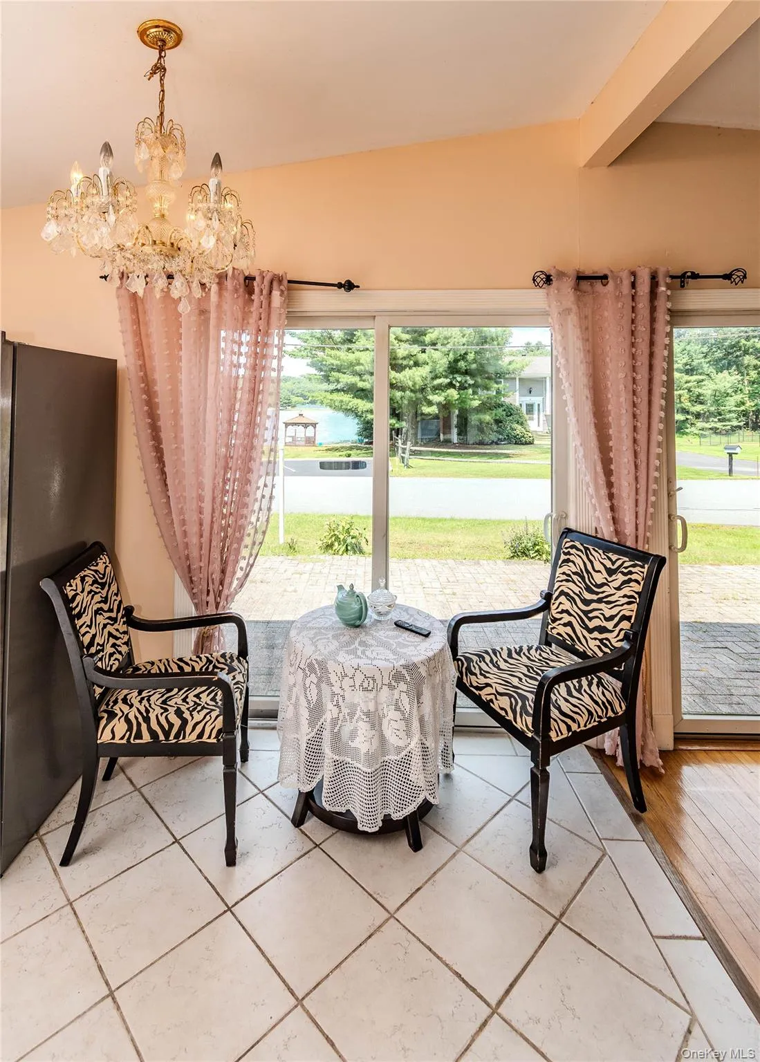White tile flooring, vaulted ceiling, and sliding glass door White tile flooring, vaulted ceiling, and sliding glass door