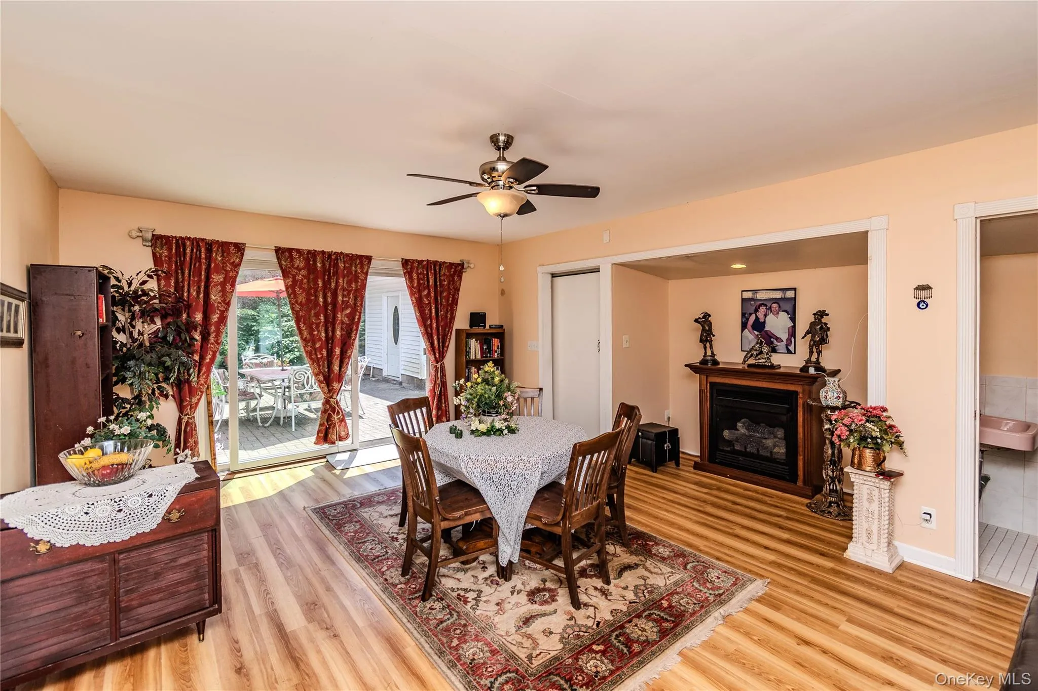 Wood-finish flooring throughout, with a ceiling fan with integrated lighting, and a built-in fireplace feature Wood-finish flooring throughout, with a ceiling fan with integrated lighting, and a built-in fireplace feature
