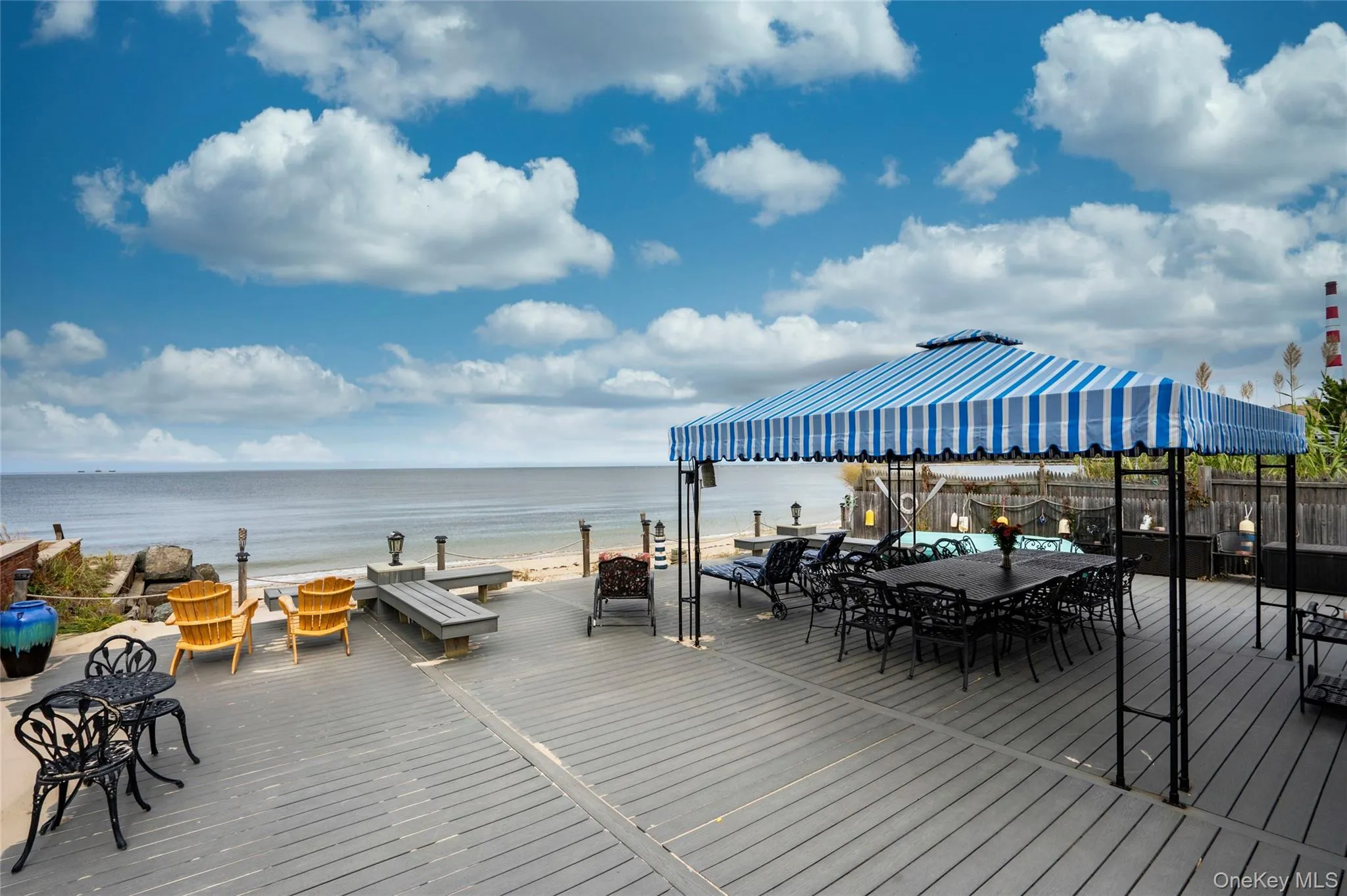 Spacious deck with beach access and plenty of room for entertaining. Awning will be taken down for winter. Spacious deck with beach access and plenty of room for entertaining. Awning will be taken down for winter.
