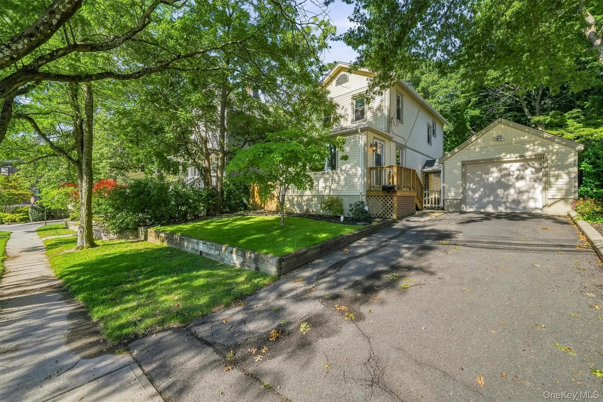 A detached garage, and a paved driveway. Sidewalk in front of house A detached garage, and a paved driveway. Sidewalk in front of house