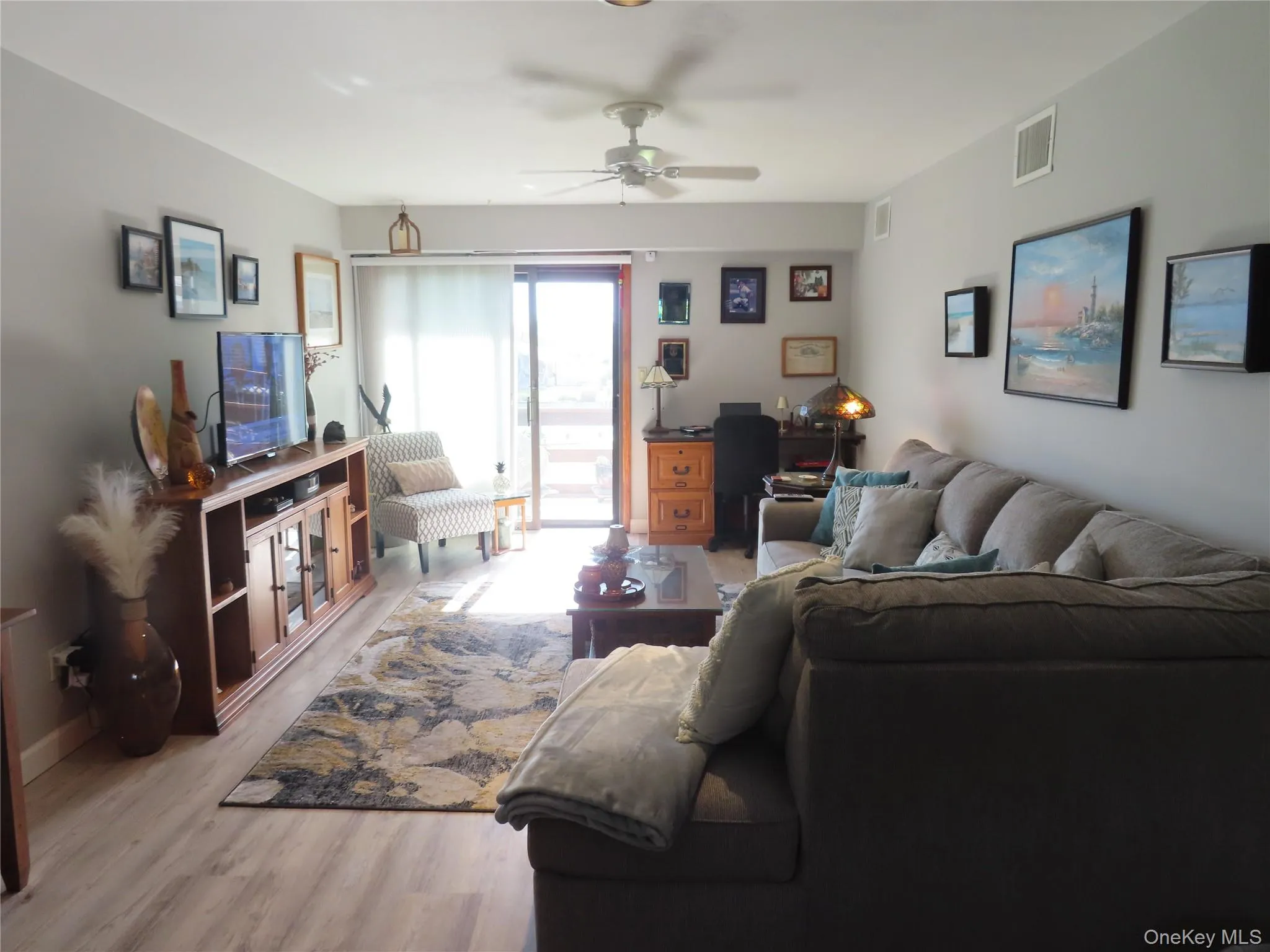 Formal Living Room with laminate floors, leading to a deck overlooking the bay Formal Living Room with laminate floors, leading to a deck overlooking the bay