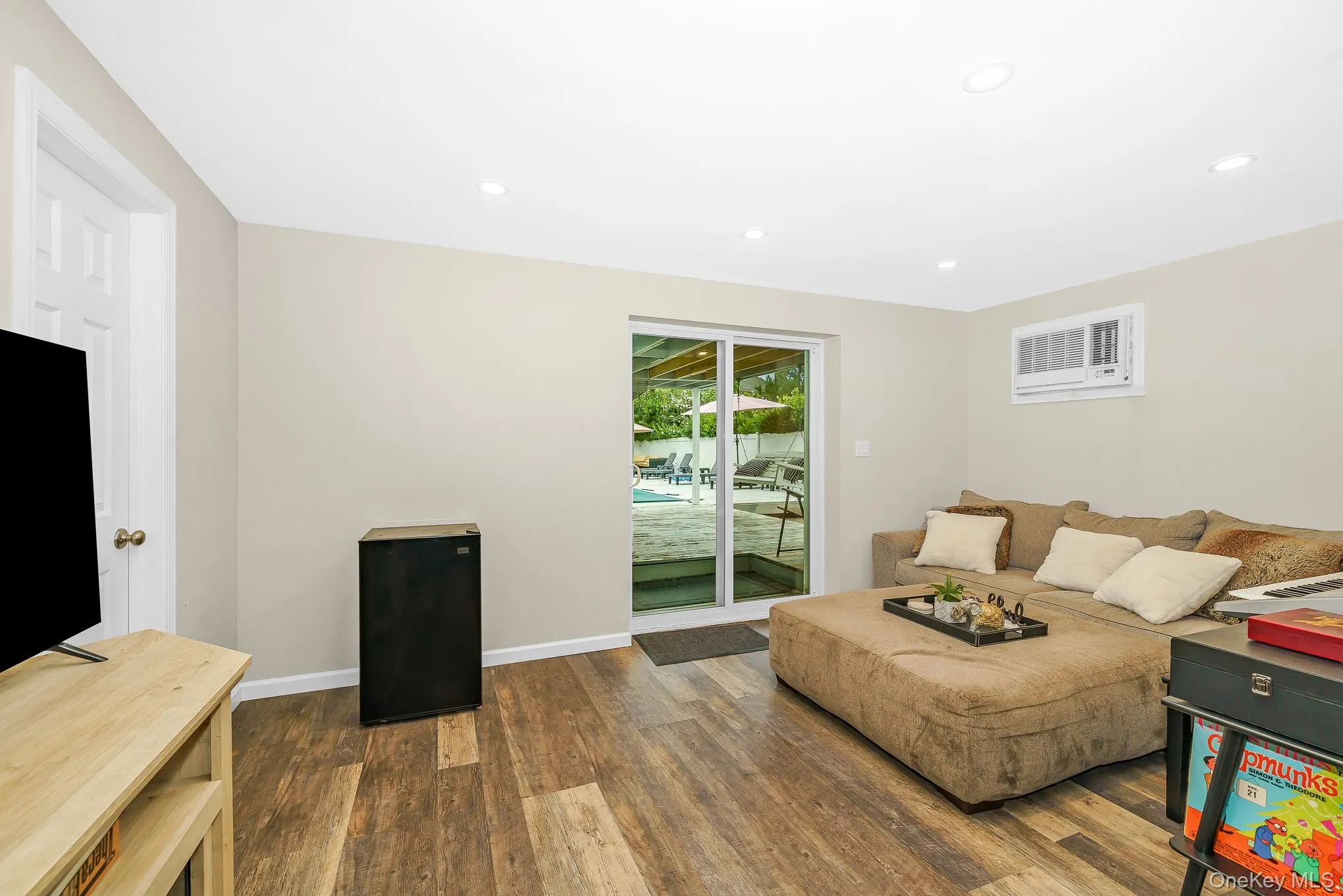 Wood-finish flooring, recessed lighting, and a sliding glass door Wood-finish flooring, recessed lighting, and a sliding glass door