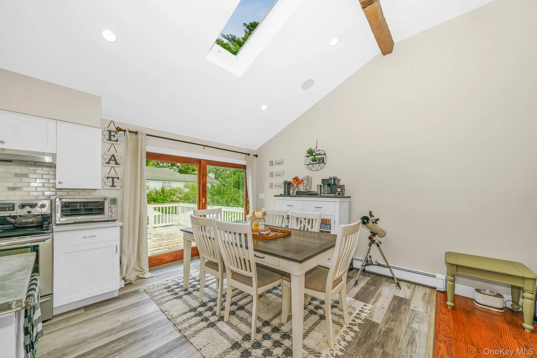 Vaulted ceiling with exposed wood beam, skylight, recessed lighting, and sliding glass door leading to large spacious deck Vaulted ceiling with exposed wood beam, skylight, recessed lighting, and sliding glass door leading to large spacious deck