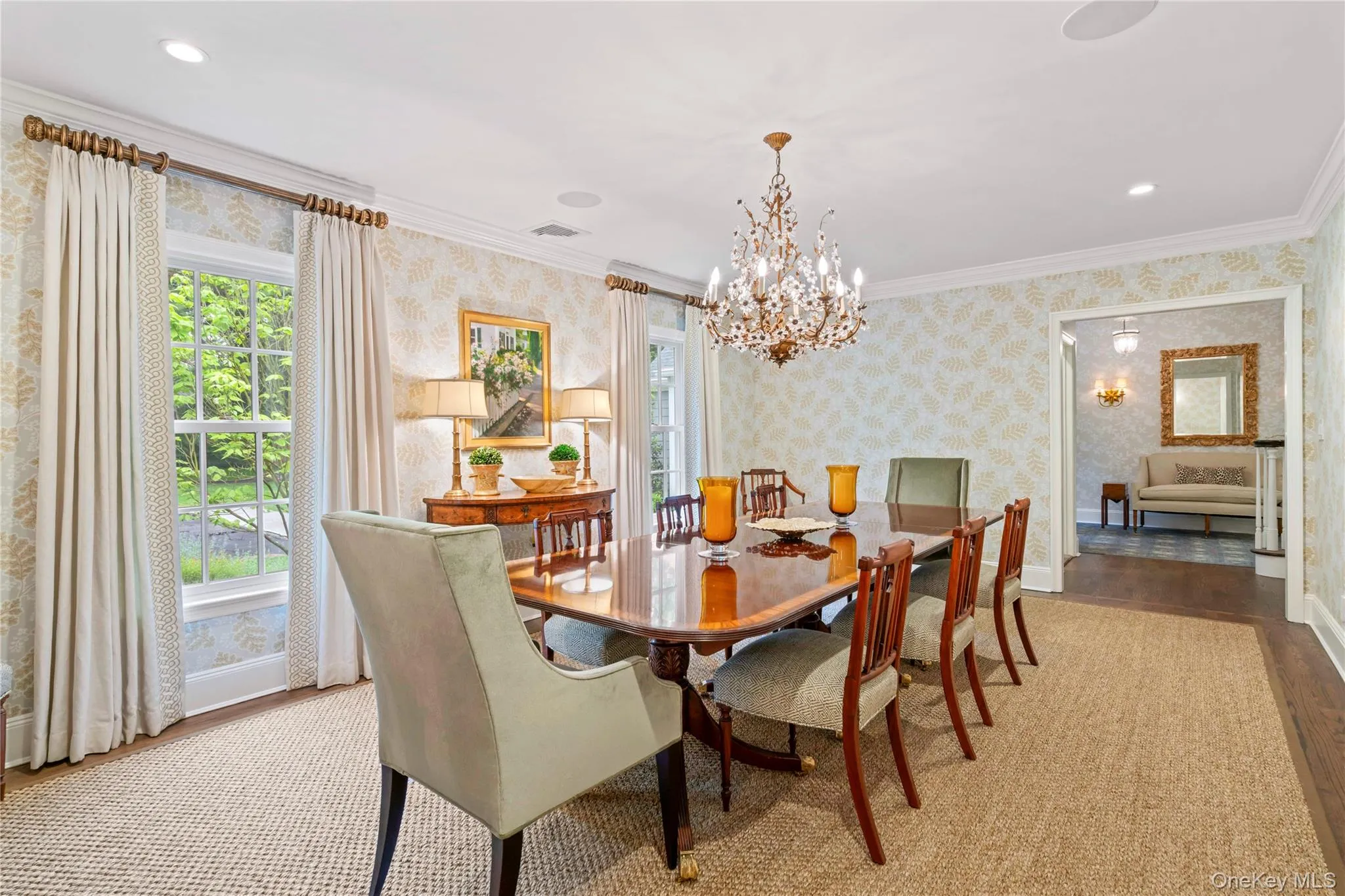 Formal Dining room with wood finished floors, wallpapered walls, healthy amount of natural light, a chandelier, and ornamental molding. Formal Dining room with wood finished floors, wallpapered walls, healthy amount of natural light, a chandelier, and ornamental molding.
