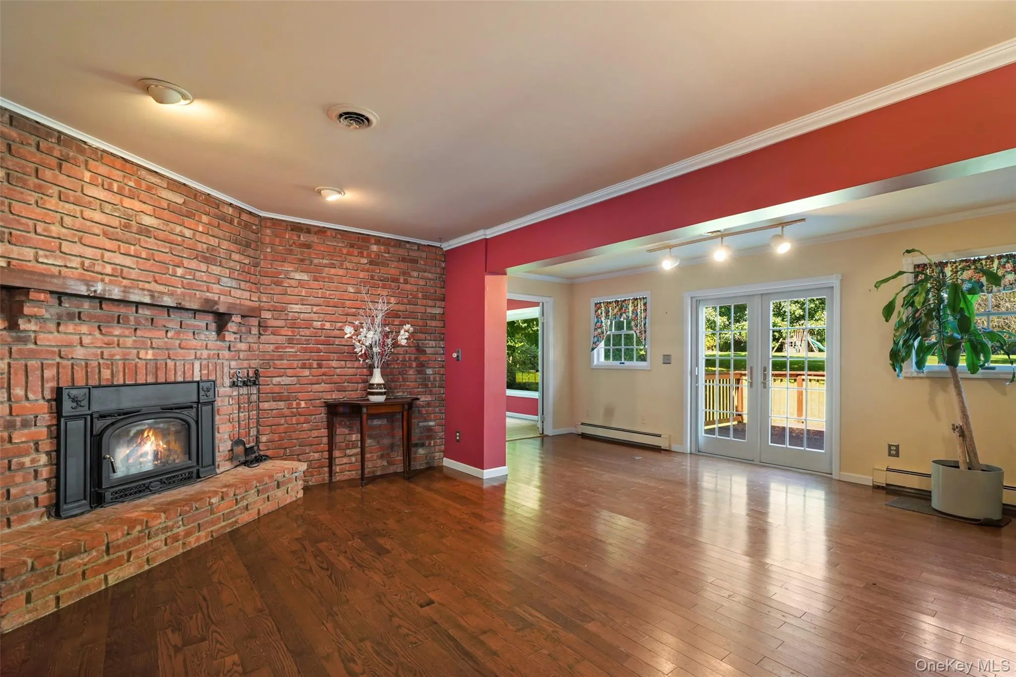 With brick hearth, wood-burning fireplace. Double doors to deck. With brick hearth, wood-burning fireplace. Double doors to deck.