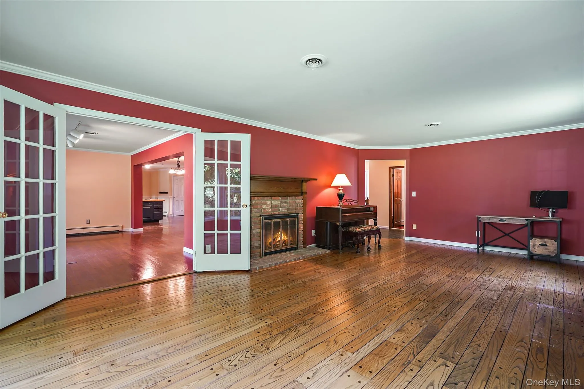 Large Living Room with wood-burning fireplace and French doors to Family Room. Original pegged hardwood floors. Large Living Room with wood-burning fireplace and French doors to Family Room. Original pegged hardwood floors.