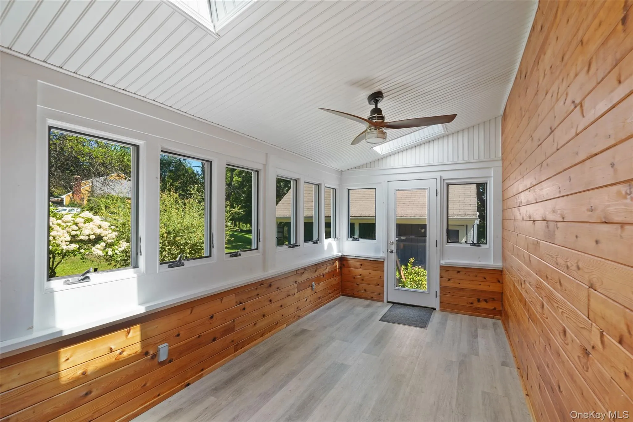 Wood paneled enclosed patio/3 season room off the Kitchen with door to driveway Wood paneled enclosed patio/3 season room off the Kitchen with door to driveway