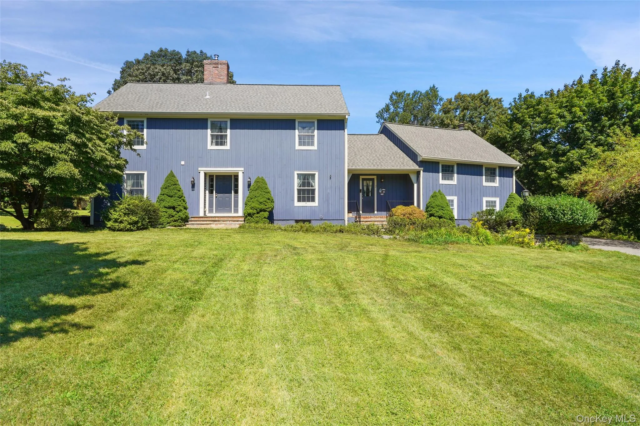 Sweeping front lawn with view of front door and side door (which accesses the Mudroom/Laundry Room and Kitchen). Sweeping front lawn with view of front door and side door (which accesses the Mudroom/Laundry Room and Kitchen).