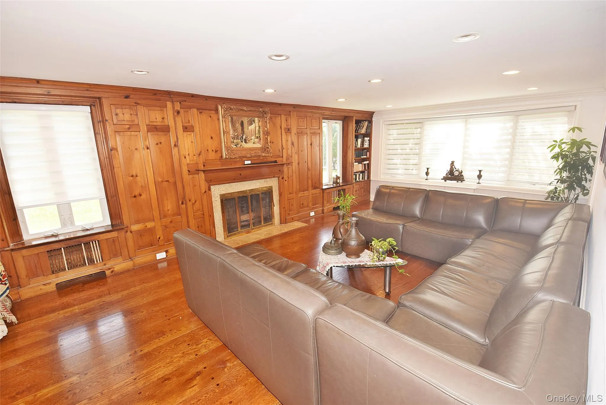 Recessed lighting illuminates wood-paneled walls, a built-in fireplace, and wood-finish flooring Recessed lighting illuminates wood-paneled walls, a built-in fireplace, and wood-finish flooring