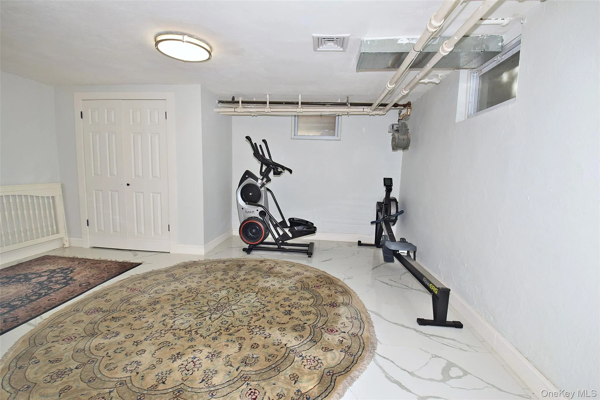 Recessed ceiling light, white paneled bifold doors, light-toned walls, and white-finish flooring Recessed ceiling light, white paneled bifold doors, light-toned walls, and white-finish flooring