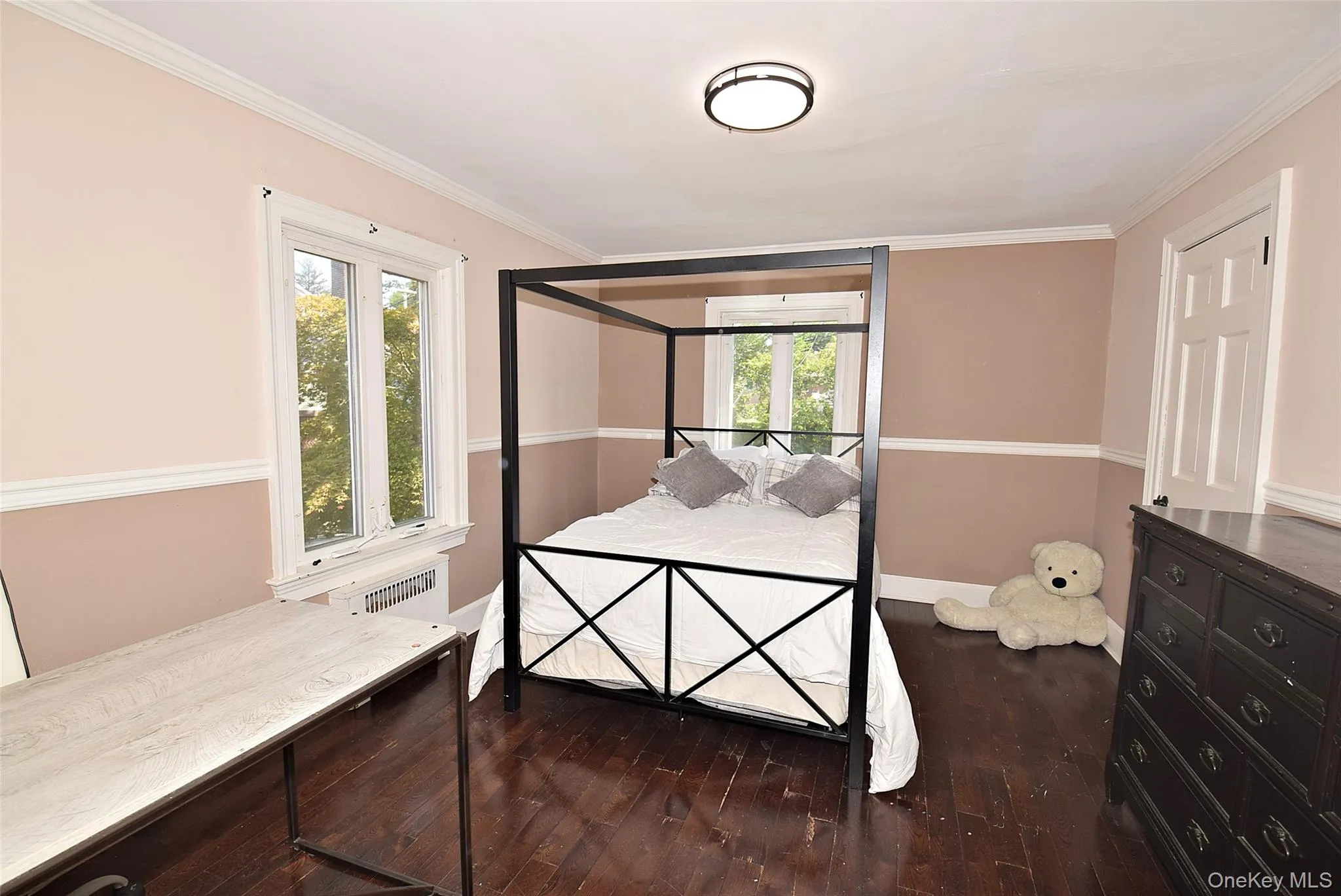 Hardwood flooring, painted paneled door, crown molding, chair rail, and a flush mount ceiling fixture Hardwood flooring, painted paneled door, crown molding, chair rail, and a flush mount ceiling fixture