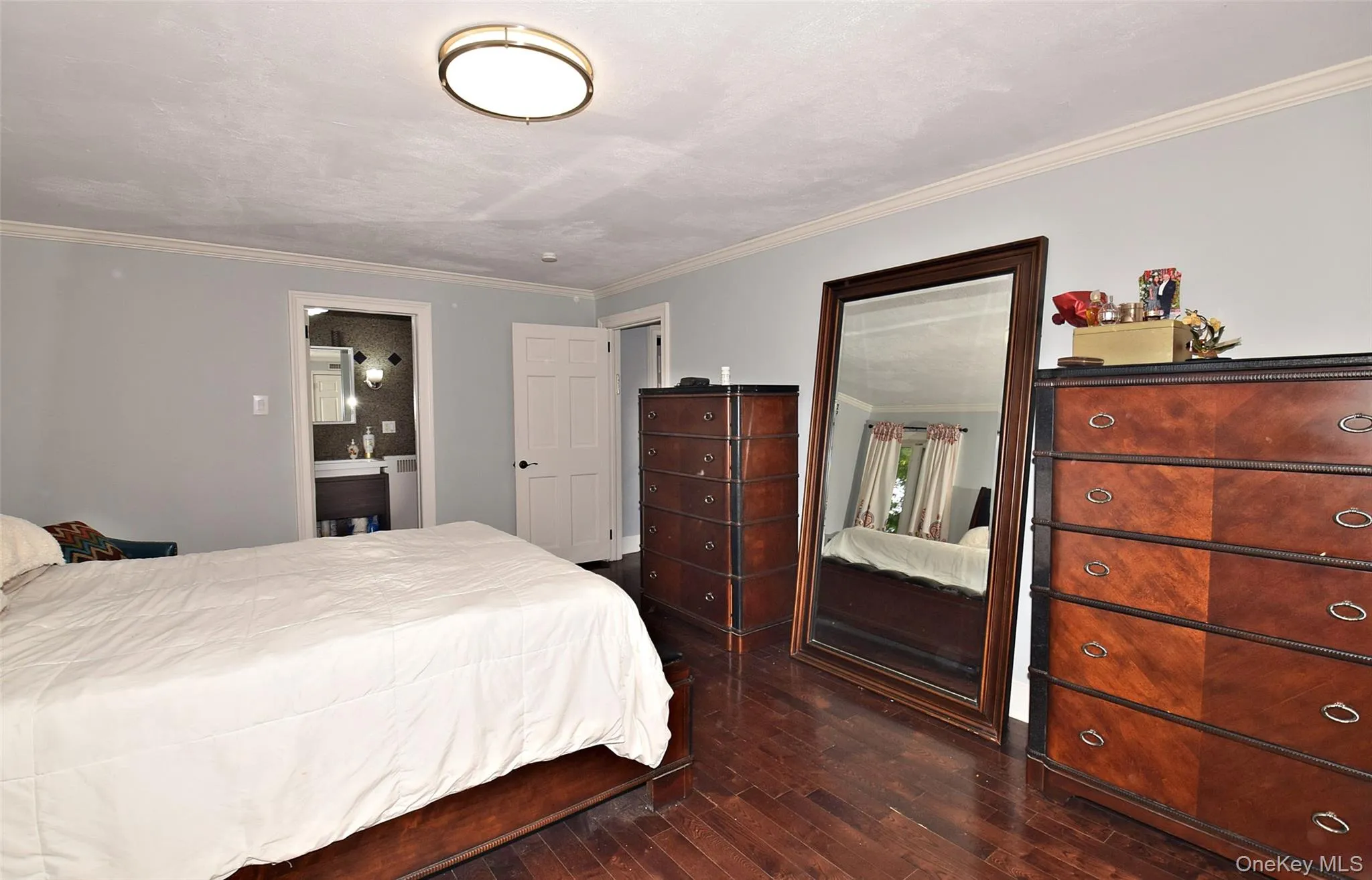 Hardwood flooring, crown molding, flush mount ceiling light fixture, attached bathroom with vanity Hardwood flooring, crown molding, flush mount ceiling light fixture, attached bathroom with vanity